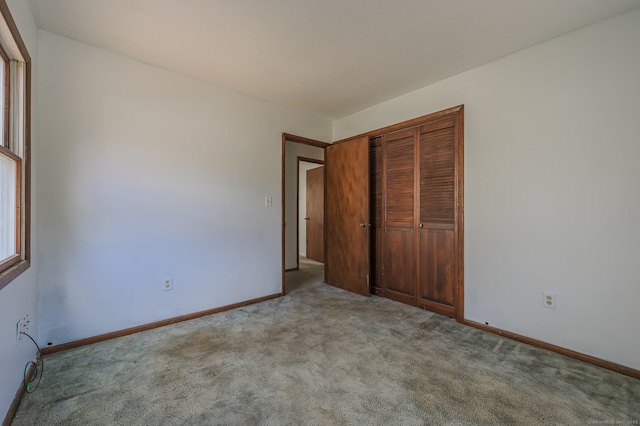 unfurnished bedroom with light carpet and a closet