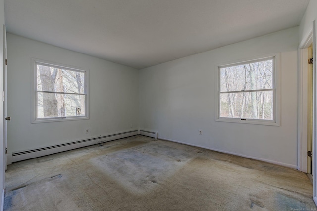 unfurnished room featuring a baseboard radiator, light colored carpet, and a wealth of natural light