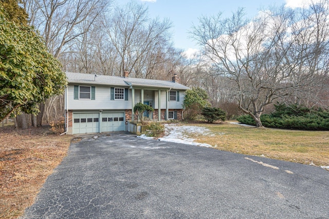 raised ranch with a porch, a garage, and a front lawn