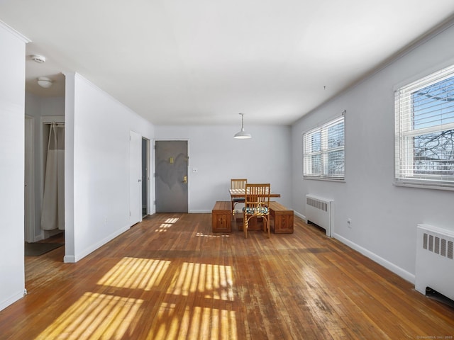 unfurnished dining area with dark wood-type flooring and radiator heating unit