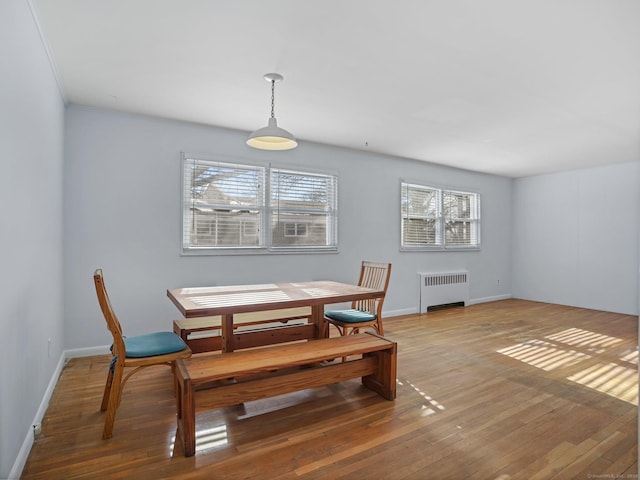 dining area featuring radiator and hardwood / wood-style floors