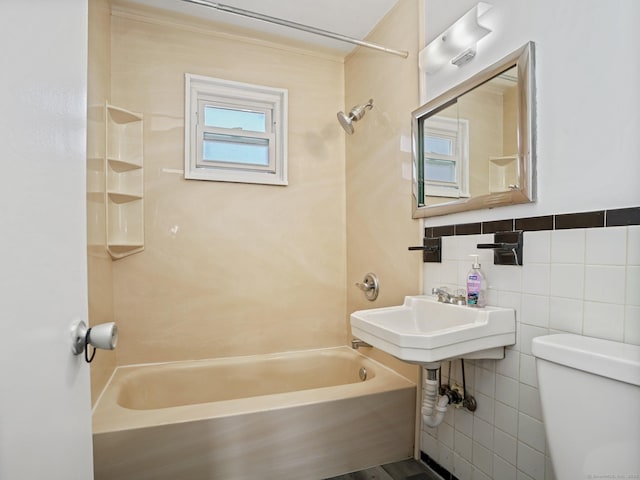 bathroom with toilet, shower / bathing tub combination, and tile walls