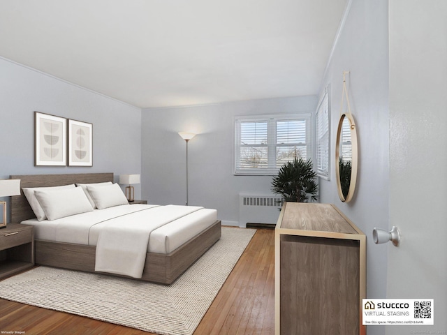 bedroom featuring wood-type flooring and radiator heating unit