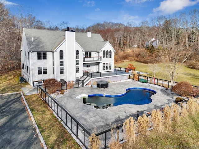 back of property with cooling unit, a balcony, and a patio