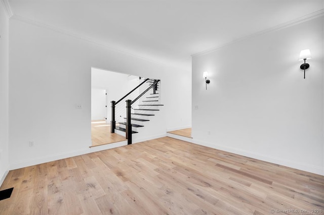 unfurnished living room with ornamental molding and light wood-type flooring