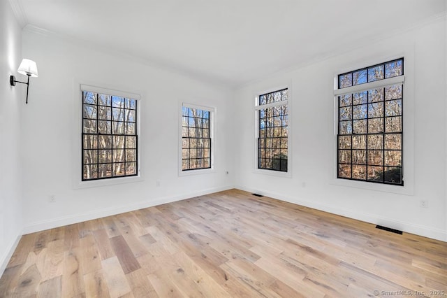 spare room with crown molding and light hardwood / wood-style floors