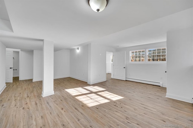 basement featuring baseboard heating and light wood-type flooring