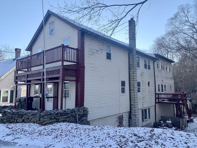 snow covered property featuring a balcony