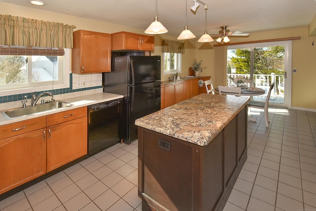 kitchen with light tile patterned floors, hanging light fixtures, backsplash, a sink, and black appliances