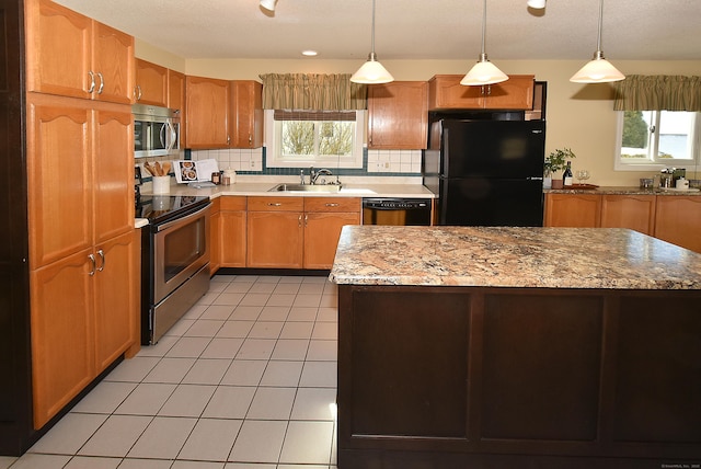 kitchen with tasteful backsplash, pendant lighting, a sink, and black appliances