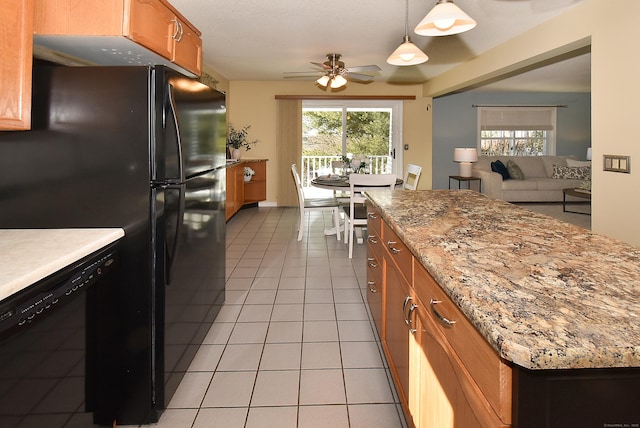 kitchen featuring light tile patterned floors, hanging light fixtures, a wealth of natural light, black appliances, and brown cabinetry