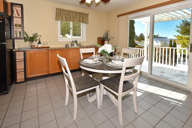 dining space with light tile patterned floors and ceiling fan