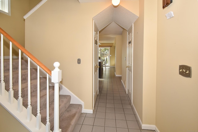 corridor with tile patterned flooring, stairway, and baseboards