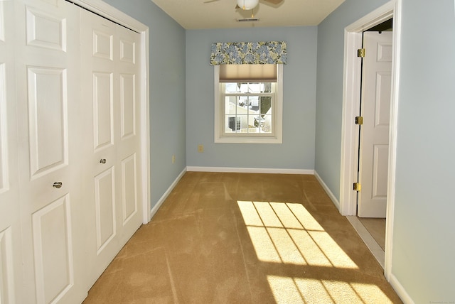 unfurnished bedroom featuring light colored carpet, a closet, visible vents, and baseboards