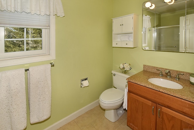 full bath featuring toilet, a stall shower, vanity, baseboards, and tile patterned floors