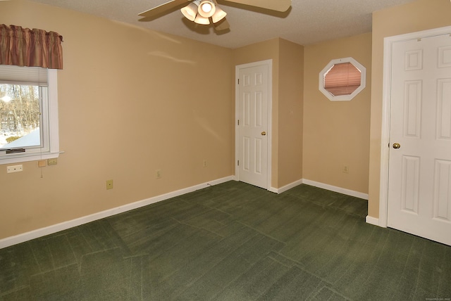 unfurnished bedroom featuring a ceiling fan, dark carpet, and baseboards