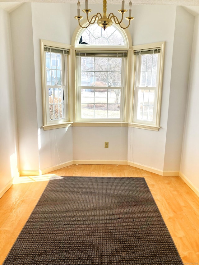 spare room featuring light hardwood / wood-style floors and a chandelier