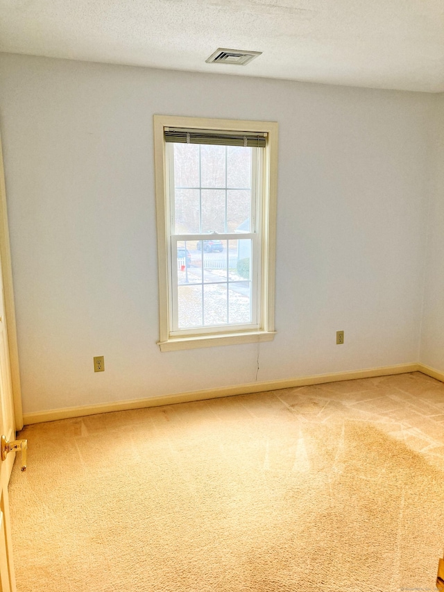 carpeted empty room with a textured ceiling