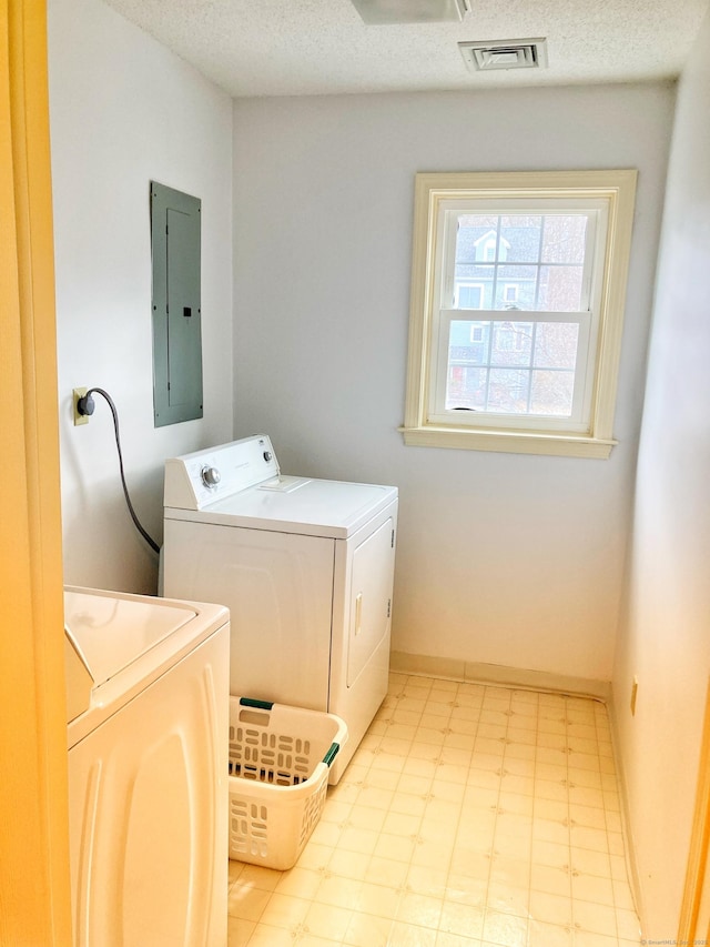 laundry area featuring washer and dryer, electric panel, and a textured ceiling