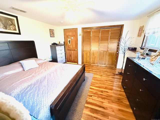 bedroom featuring ceiling fan, a closet, and light hardwood / wood-style flooring