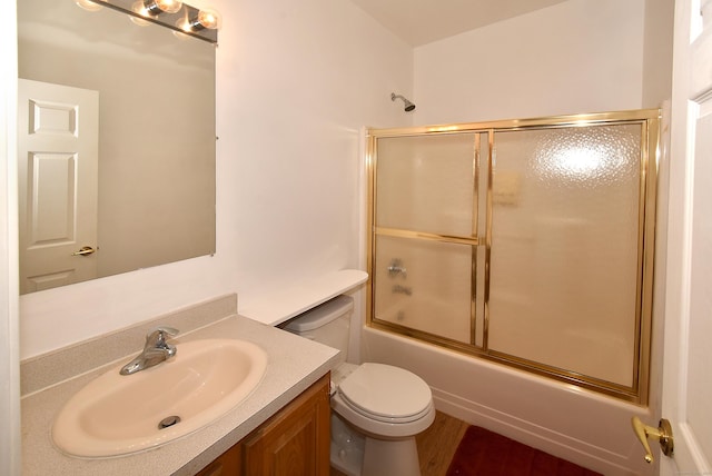 full bathroom featuring vanity, toilet, and combined bath / shower with glass door