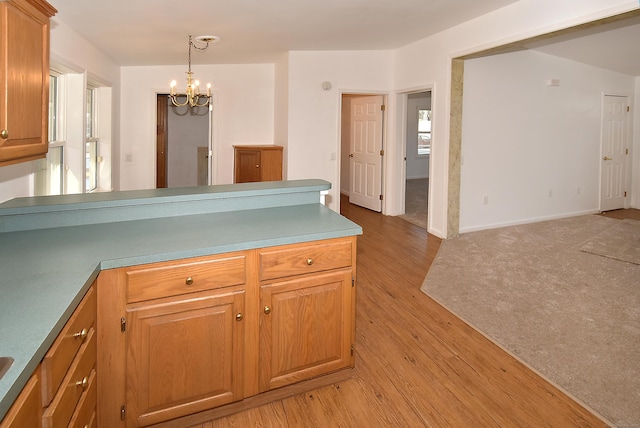 kitchen featuring an inviting chandelier, decorative light fixtures, and light hardwood / wood-style flooring