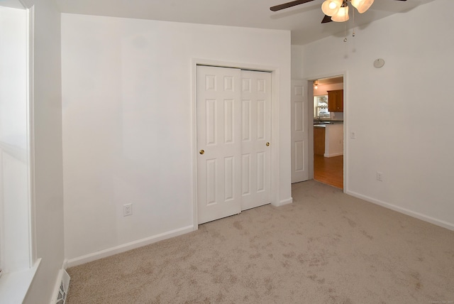 unfurnished bedroom with light carpet, a closet, and ceiling fan