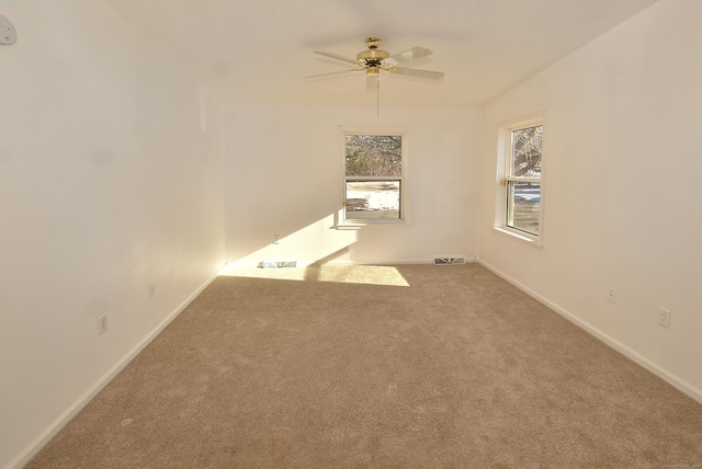 carpeted spare room with ceiling fan