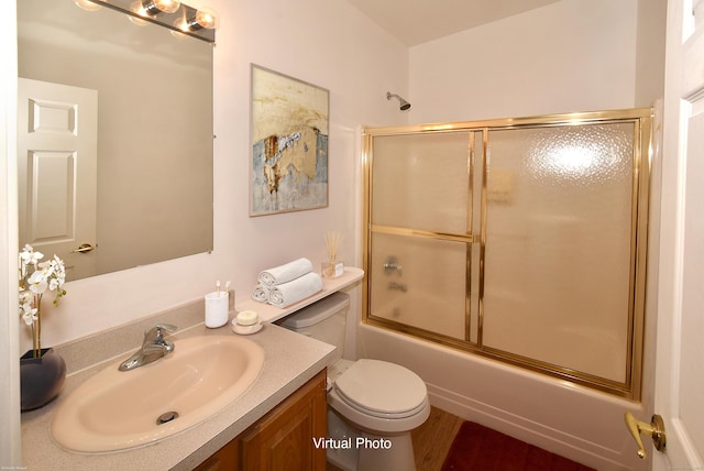 full bathroom featuring vanity, shower / bath combination with glass door, and toilet