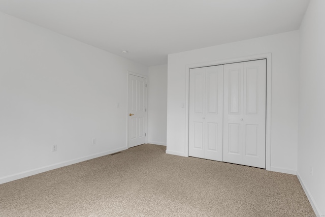 unfurnished bedroom featuring carpet floors and a closet