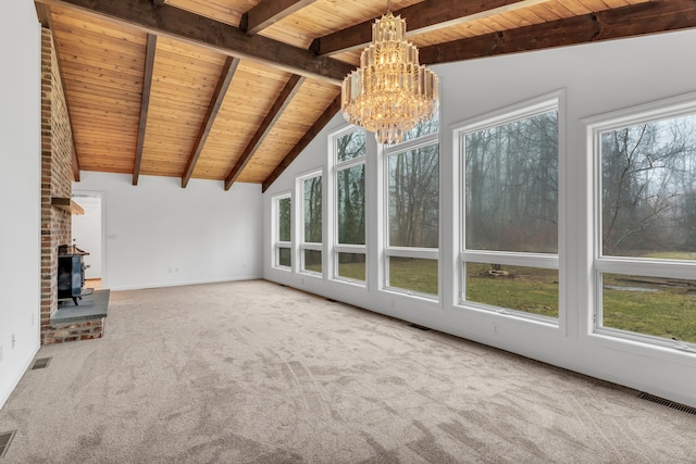 unfurnished living room with a wood stove, wooden ceiling, a healthy amount of sunlight, and carpet