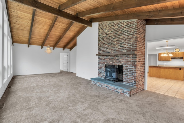 unfurnished living room featuring high vaulted ceiling, a wood stove, wooden ceiling, light colored carpet, and beam ceiling