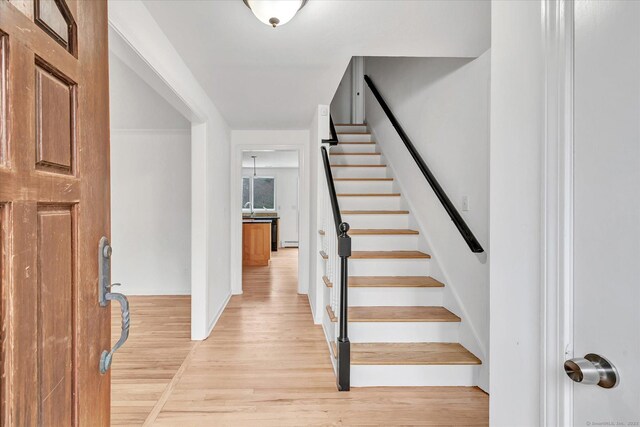 foyer entrance featuring light hardwood / wood-style floors and a baseboard heating unit