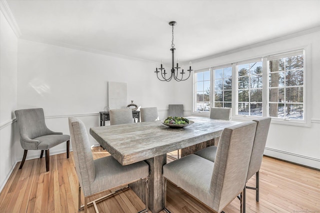 dining space with a notable chandelier, a baseboard radiator, ornamental molding, and light wood-type flooring