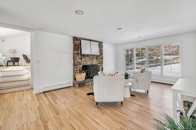 living room with a baseboard heating unit and light hardwood / wood-style floors