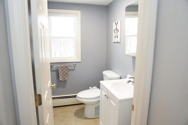 bathroom featuring toilet, a wealth of natural light, vanity, and a baseboard radiator