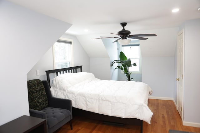 bedroom featuring multiple windows, hardwood / wood-style flooring, vaulted ceiling, and ceiling fan