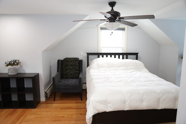 bedroom featuring hardwood / wood-style flooring, ceiling fan, vaulted ceiling, and a baseboard radiator