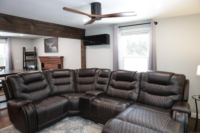 home theater featuring ceiling fan, hardwood / wood-style floors, and a healthy amount of sunlight