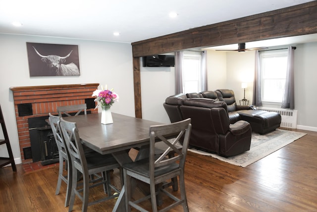 dining area with radiator, dark hardwood / wood-style flooring, and a fireplace