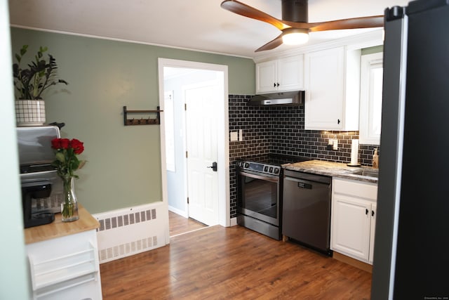 kitchen with radiator, dark hardwood / wood-style flooring, stainless steel appliances, and white cabinets