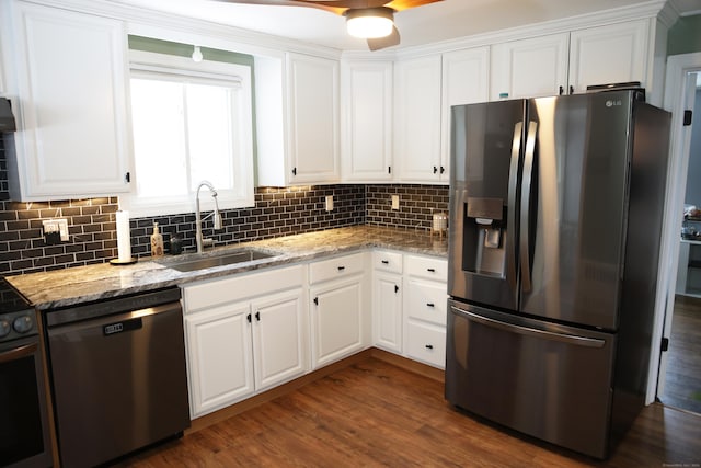 kitchen with white cabinetry, stainless steel appliances, light stone counters, and sink