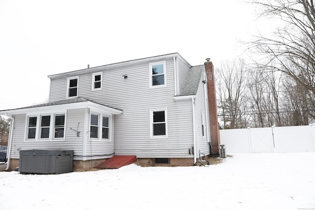 snow covered rear of property with central air condition unit