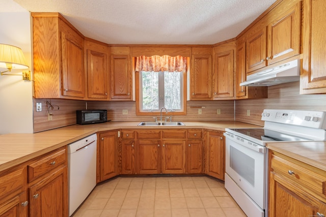 kitchen featuring sink, backsplash, a textured ceiling, and white appliances