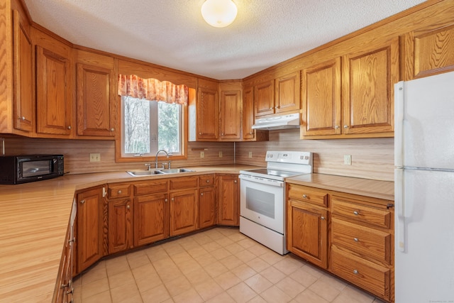 kitchen featuring sink, white appliances, a textured ceiling, and backsplash