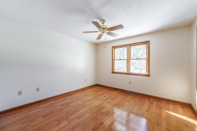 spare room with ceiling fan, a textured ceiling, and light hardwood / wood-style floors