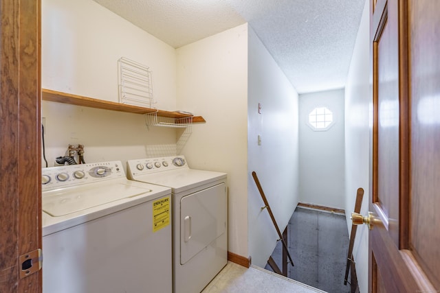 clothes washing area featuring washer and clothes dryer and a textured ceiling