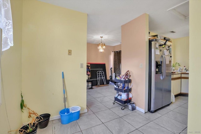 kitchen featuring hanging light fixtures, light tile patterned floors, and stainless steel refrigerator with ice dispenser