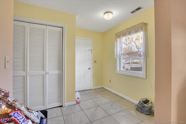 tiled entrance foyer with a textured ceiling