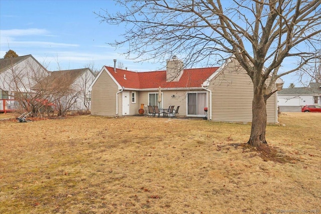 rear view of house featuring a yard